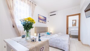 Een slaapkamer met een bed, nachtkastje en een raam met gordijnen.