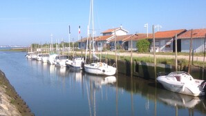 Un canal amb diverses embarcacions amarrades al marge.
