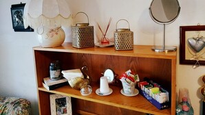 A wooden shelf with various decorative items, including a vase, lanterns, a mirror, and a framed picture. - Beautiful room in the center of Milis!!!<br><br> ♥ 10 minutes from the sea ♥ (Milis)