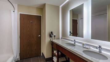 A bathroom with two sinks, a large mirror, and a wooden door.