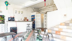 A restaurant with a colorful tiled floor, a counter with stools, and a decorative hanging ornament.