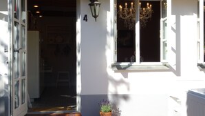 Ein Hauseingang mit der Hausnummer 4, einem Blumentopf und einer Chandelier.