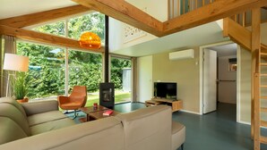 Un salon moderne avec un canapé, un fauteuil, un téléviseur et une cheminée.
