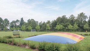 A large, colorful, semi-circular structure in a park with a grassy field, trees, and a playground in the background. - Amazing home in Bruinisse with kitchen (Bruinisse)