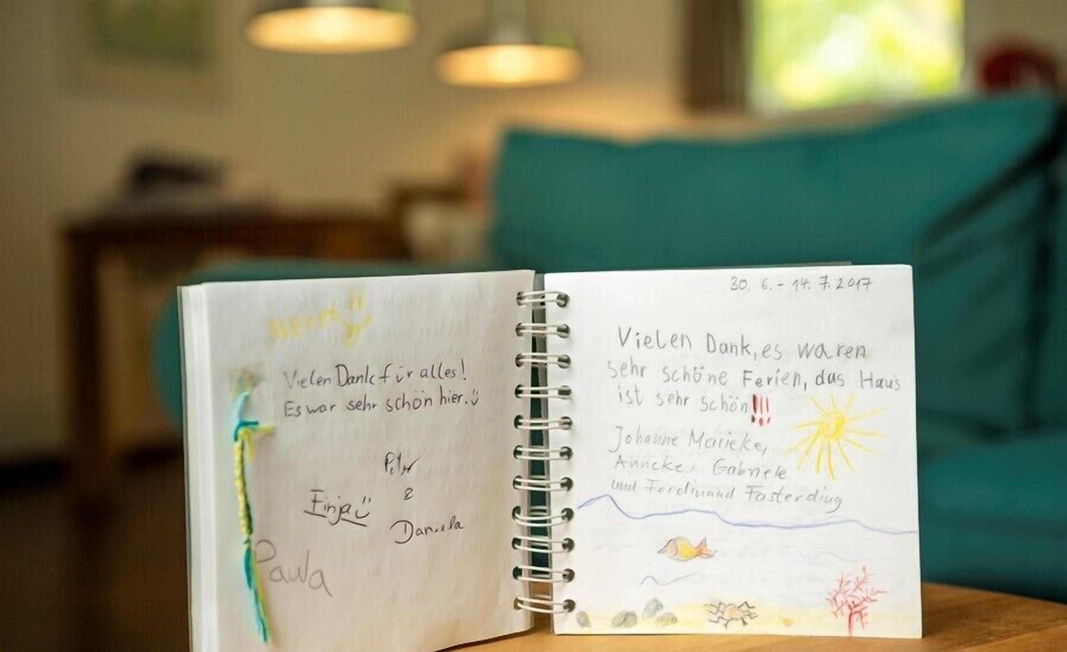 Un carnet ouvert, avec des notes manuscrites et un dessin, posé sur une table.