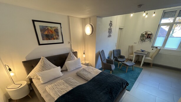 A modern bedroom with a large bed, bedside tables, a desk, and a chair. - Dalhaus farm: Our "pantry" (Lüdinghausen)