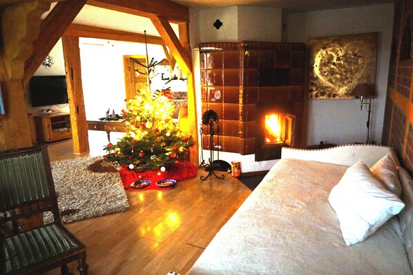 A cozy room with a wooden floor, a bed with white bedding, a Christmas tree, and a fireplace. - Family house, Villa Country house, 10 pers,
3 apartments, 3 bathroom, 3 kitchen (Hemmoor)