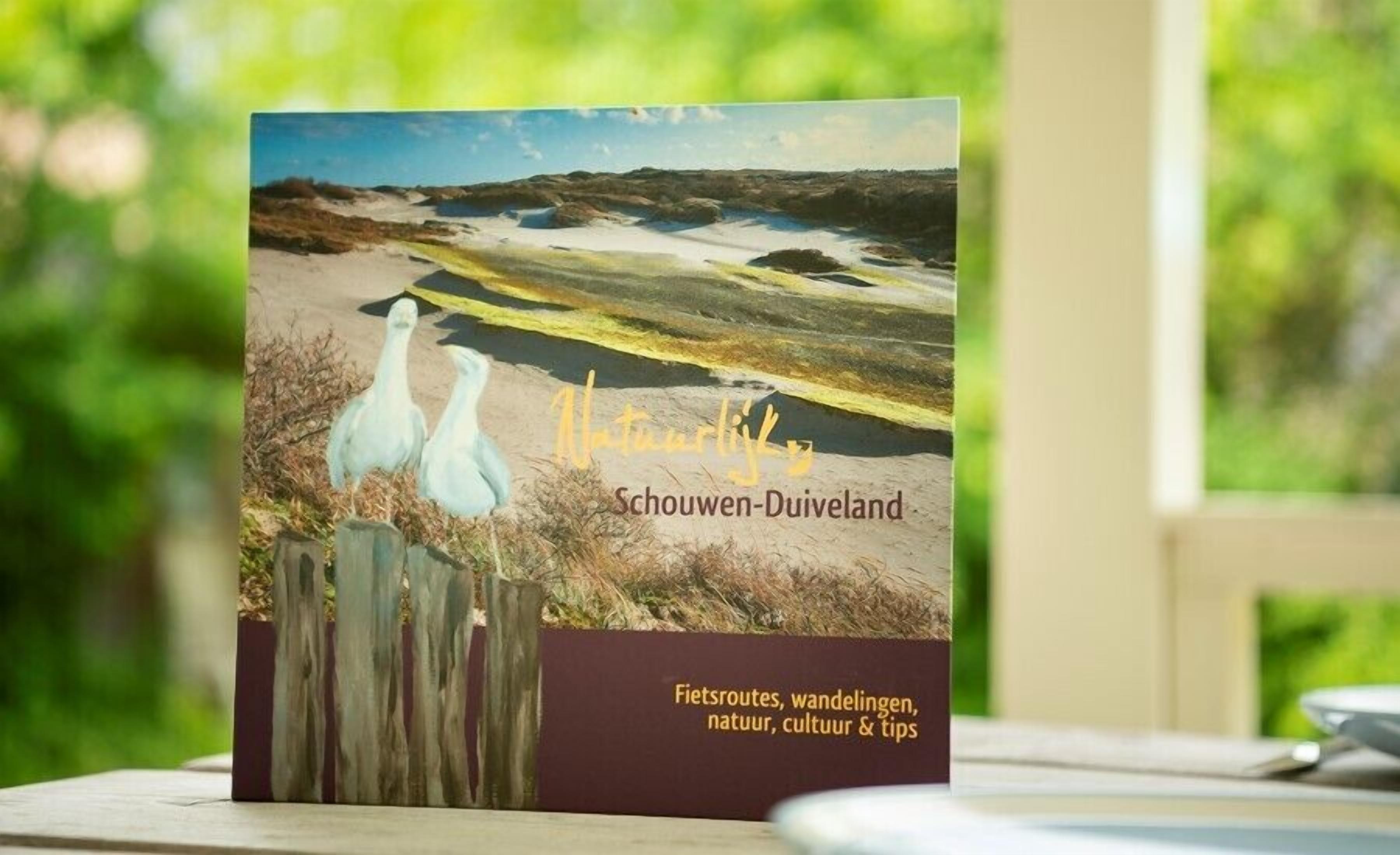 A book titled 'Natuurleven' with a cover depicting a landscape and two birds.