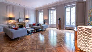 Ein geräumiges Wohnzimmer mit Kamin, einer Sofagarnitur und einem großen Fenster für natürliches Licht.