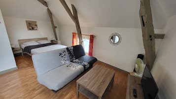 Une pièce comprenant un lit, un canapé, une table et un miroir.