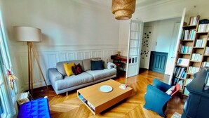 A living room with a sofa, coffee table, and bookshelf.