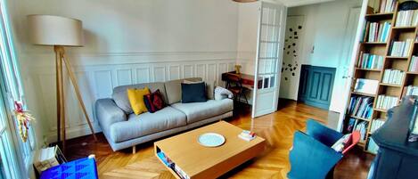 Ein Wohnzimmer mit einer Couch, einem Couchtisch und einem Bücherregal.