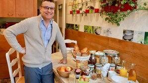Une table de petit-déjeuner avec divers aliments, et une personne debout à côté.