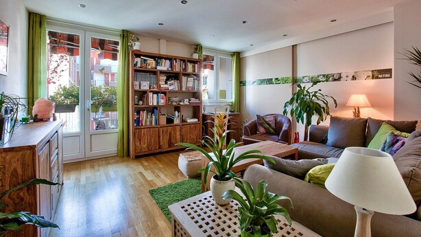 Un salon confortable avec une bibliothèque, un canapé, une table basse et une lampe.
