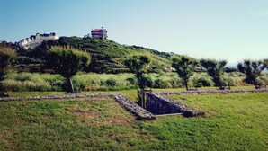 A hilltop building with a red roof, surrounded by greenery and stone pathways. - Apartment in detached house, quiet residential area "L'Orée du lac" (Biarritz)