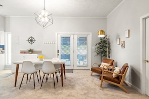 Un coin repas comprenant une table et des chaises, un luminaire suspendu et une plante.