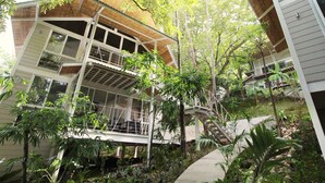 Una casa de varios niveles con una terraza de madera y una escalera que sube a los pisos superiores.
