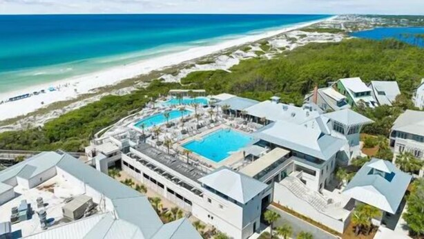Ein Resort mit großem Swimmingpool, Strandlage und moderner Architektur.