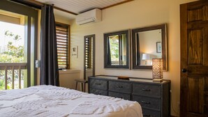 A bedroom with a bed, dresser, and a large mirror.