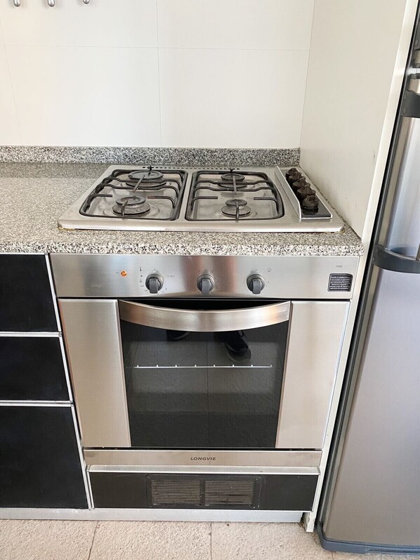 A kitchen with a stainless steel stove, oven, and a refrigerator.