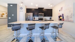 A modern kitchen with a central island, bar stools, stainless steel appliances, and pendant lighting. - (NF4909) Home 4/3 Private Pool & Free Waterpark (Kissimmee)