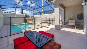 A covered outdoor area with a pool, seating, and a pergola structure. - (NF4909) Home 4/3 Private Pool & Free Waterpark (Kissimmee)