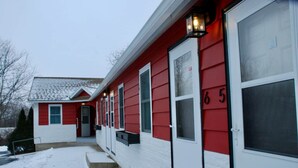 A single-story house with a red and white exterior, a front door, and a mailbox.