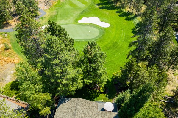 An aerial view of a golf course surrounded by dense trees. - 18 White Elm, 3 King Suites+Bunk Room! On 14th Green, Hot Tub, Bikes, 10 Passes (Sunriver)