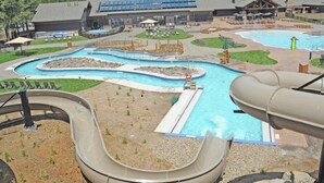 A water park with multiple slides and pools, surrounded by a lodge with large windows and solar panels. - 18 White Elm, 3 King Suites+Bunk Room! On 14th Green, Hot Tub, Bikes, 10 Passes (Sunriver)