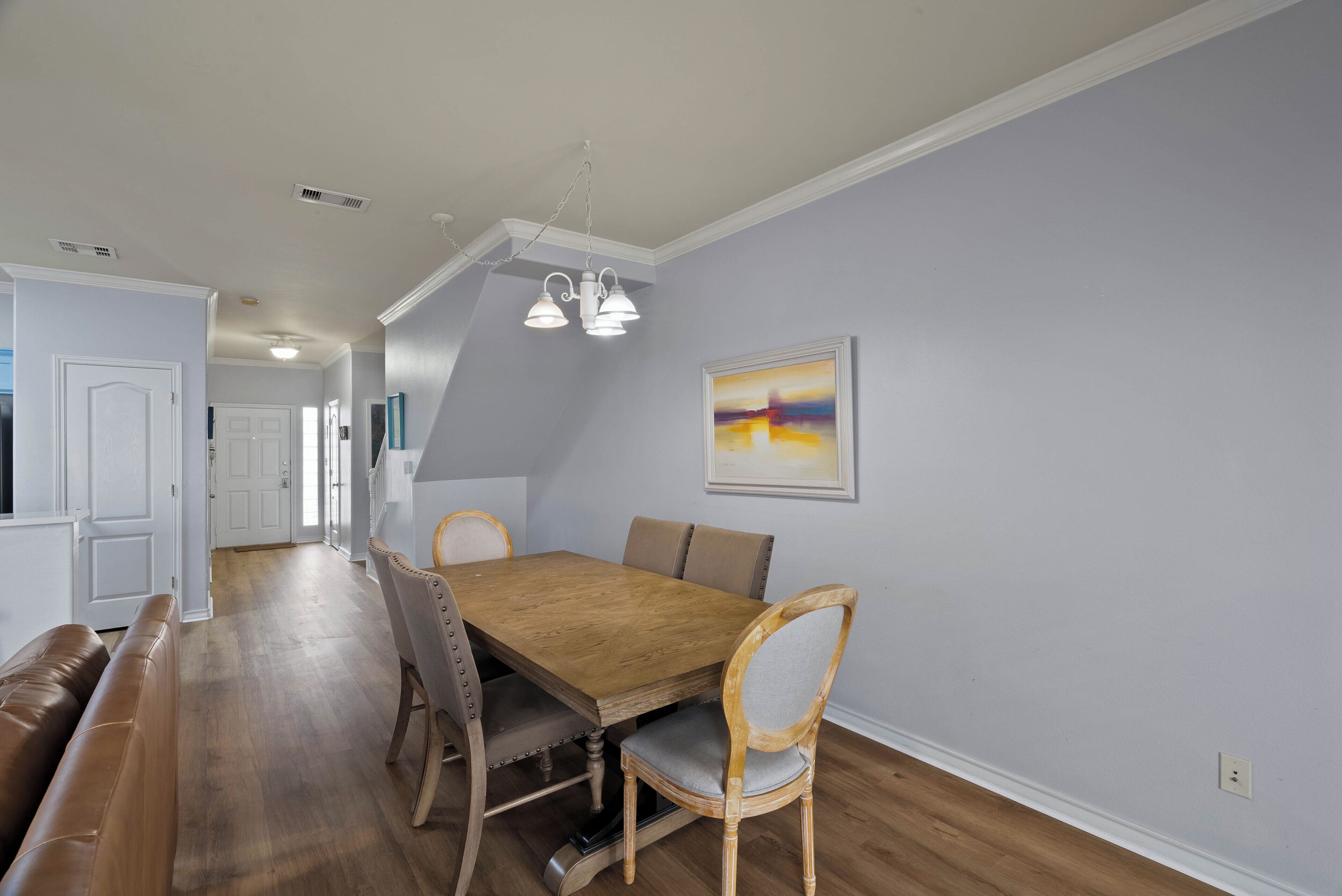 A dining area with a wooden table, four chairs, a bench, and a ceiling light fixture.