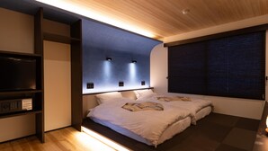 A modern bedroom with a bed, built-in shelves, and a wall-mounted light fixture.