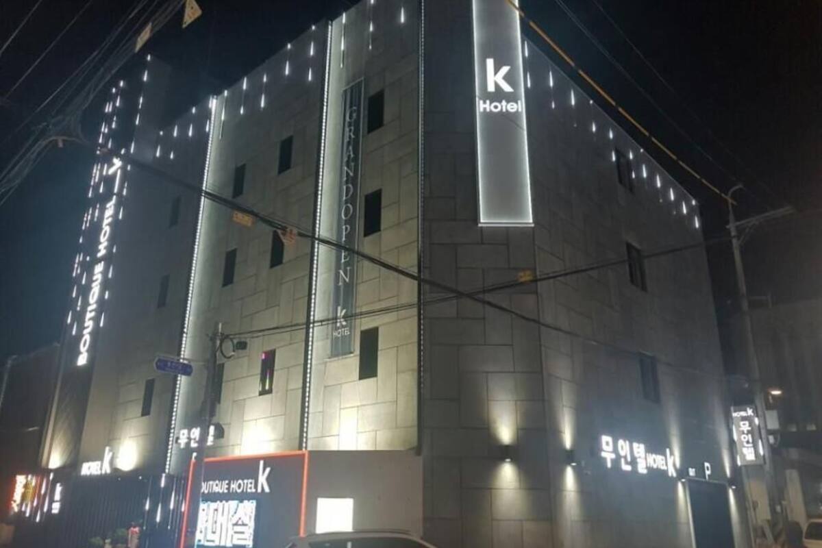 A hotel building with a prominent 'k Hotel' sign, multiple windows, and a visible entrance.