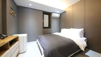 A modern bedroom with a bed, bedside table, and a wardrobe.