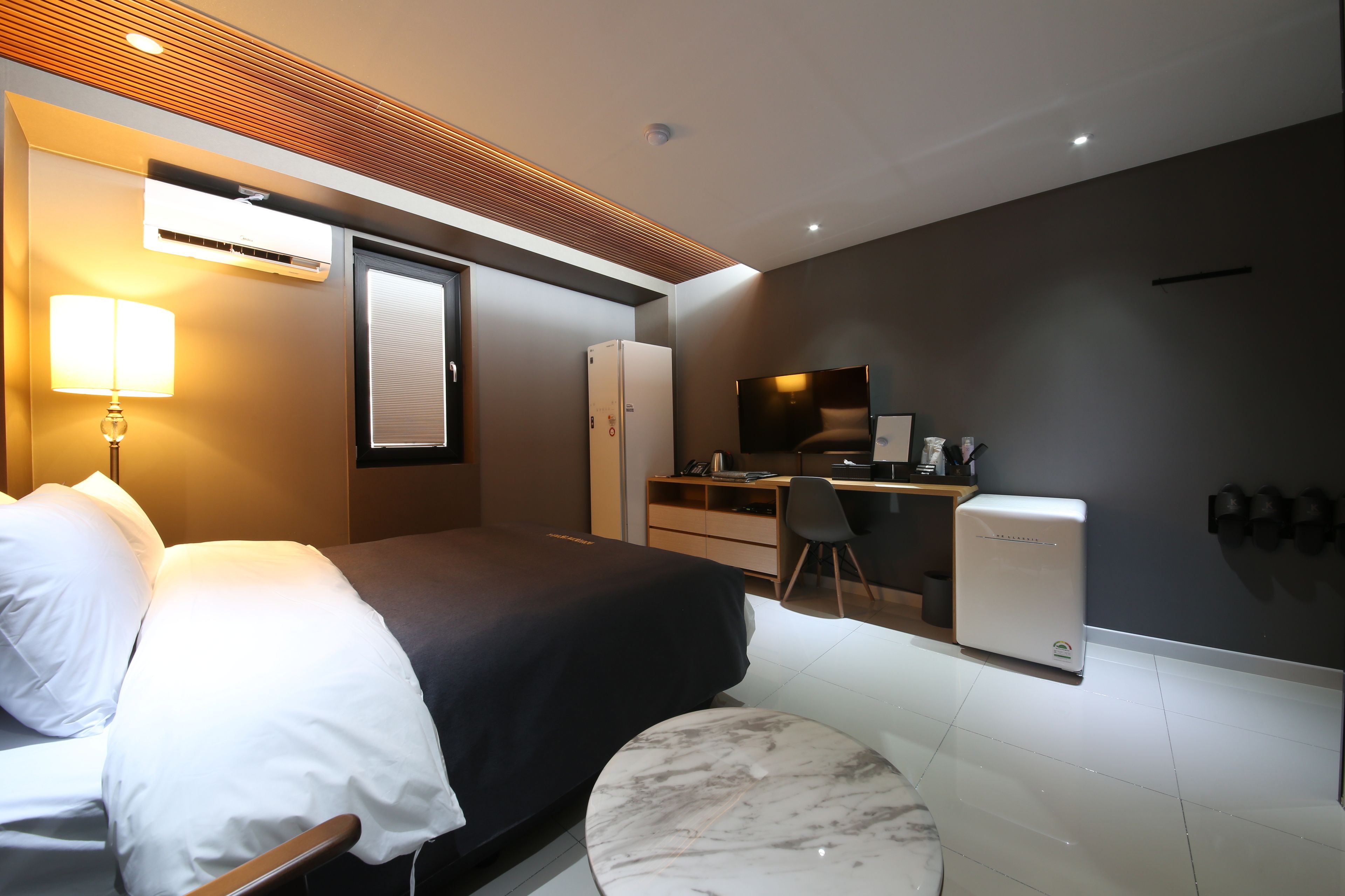 Una habitación de hotel moderna con cama, escritorio y zona de estar.