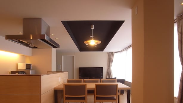 A modern kitchen with a dining area, a flat-screen TV, and a ceiling light fixture. - Kanazawa TAMARUYA (Kanazawa)