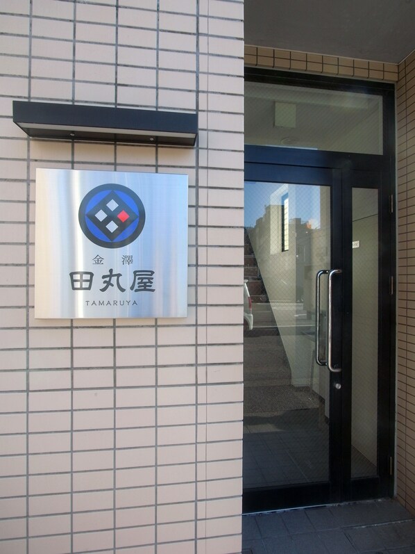 A hotel entrance with a sign displaying the name 'Tamaruya' in both English and Japanese. - Kanazawa TAMARUYA (Kanazawa)