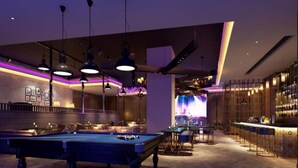 A modern bar area with pool tables, ambient lighting, and a stage for performances. - Rongjin Hotel Shenzhen (Shenzhen)