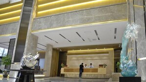 A spacious lobby with a reception desk, marble flooring, and modern lighting. - Rongjin Hotel Shenzhen (Shenzhen)