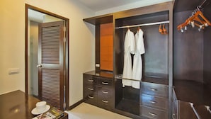 A modern hotel room with a walk-in closet, a vanity with a mirror, and a neatly arranged bed. - Oazza Villa (Rawai)