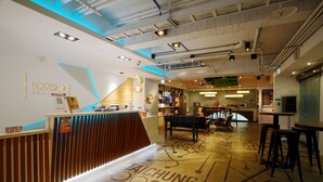 A modern hotel lobby with a reception desk, a pool table, and a bar area. - Loosha Hostel (Taichung)