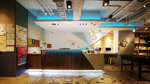 A hotel reception area with a modern design, including a reception desk, a pool table, and a lounge area with seating. - Loosha Hostel (Taichung)