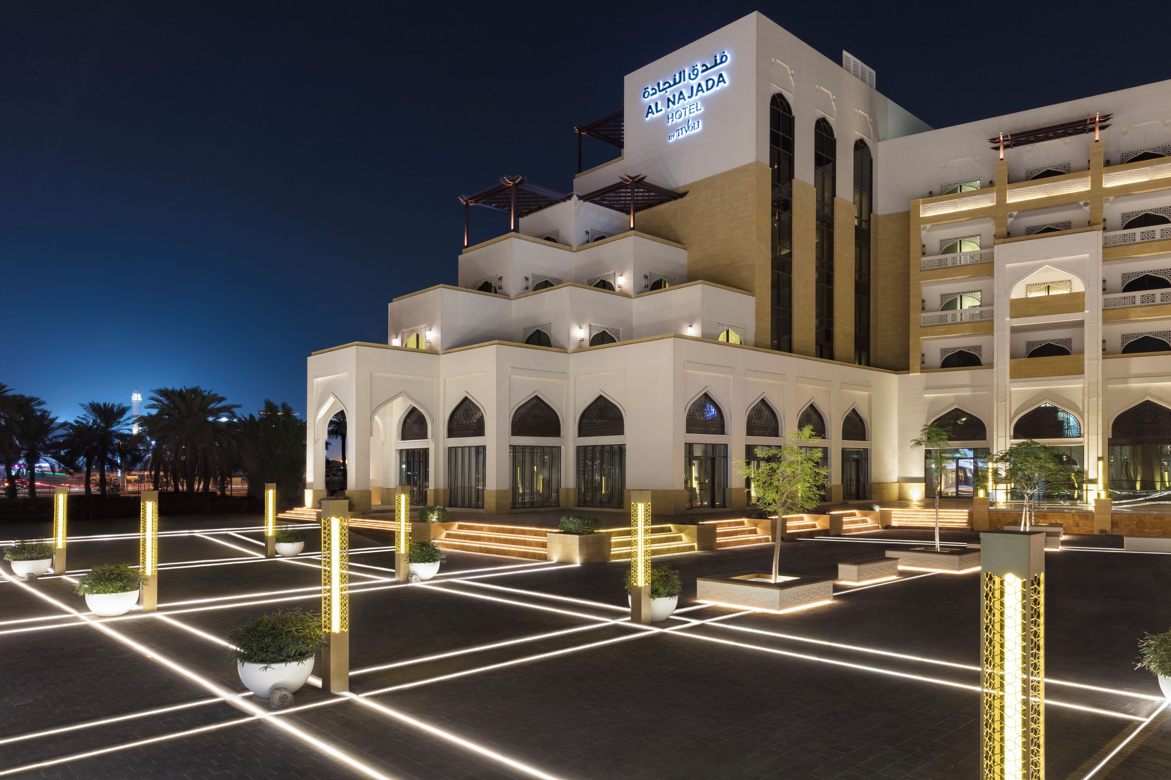 A hotel with a modern architectural design, featuring multiple levels and arched windows.