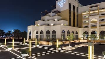 A hotel with a modern architectural design, featuring multiple levels and arched windows.