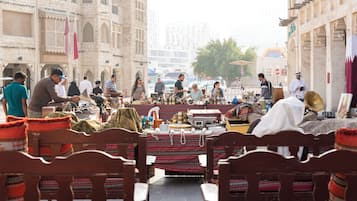 A market scene with wooden benches and tables displaying various goods.
