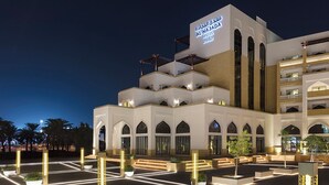 The exterior of Al Najada Hotel with a modern design, multiple balconies, and a well-lit entrance area. - Al Najada Doha Hotel by Tivoli (Doha)