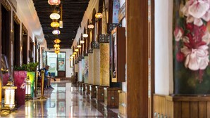 A corridor with ornate lanterns, wooden paneling, and a polished floor. - Al Najada Doha Hotel by Tivoli (Doha)