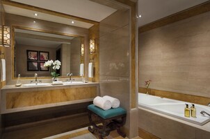 Un baño moderno con dos lavamanos, un espejo grande y una bañera.