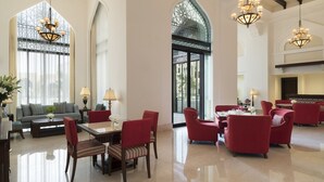 Un'ampia hall con soffitti alti, lampadari e grandi finestre.