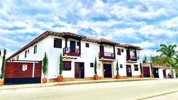 Un edificio de dos pisos con estilo arquitectónico tradicional, que cuenta con balcones y una entrada protegida por un portón.