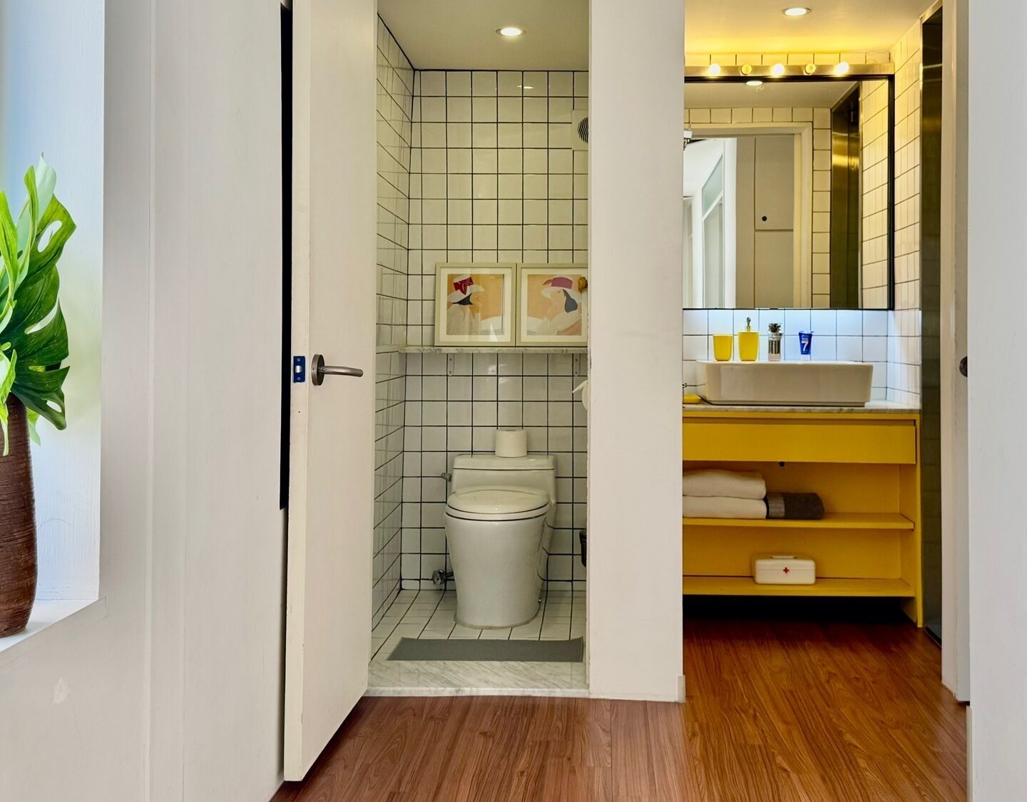 A bathroom with a toilet, a sink, and a mirror.